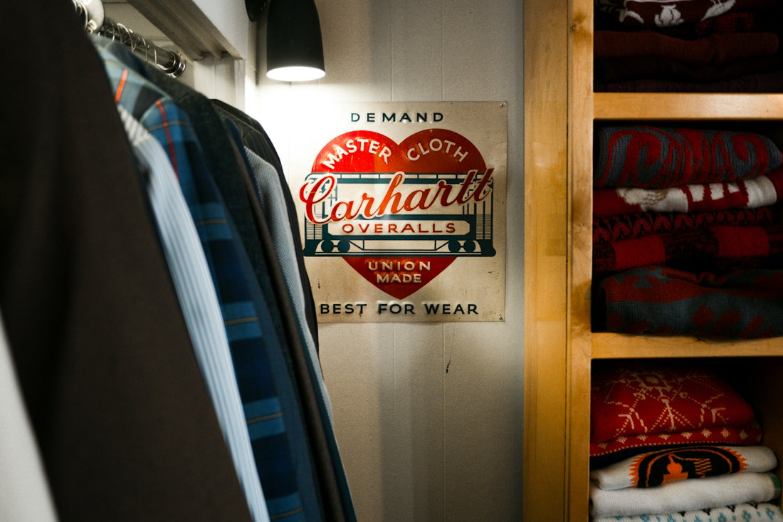 Carhartt overalls sign in a closet with clothes